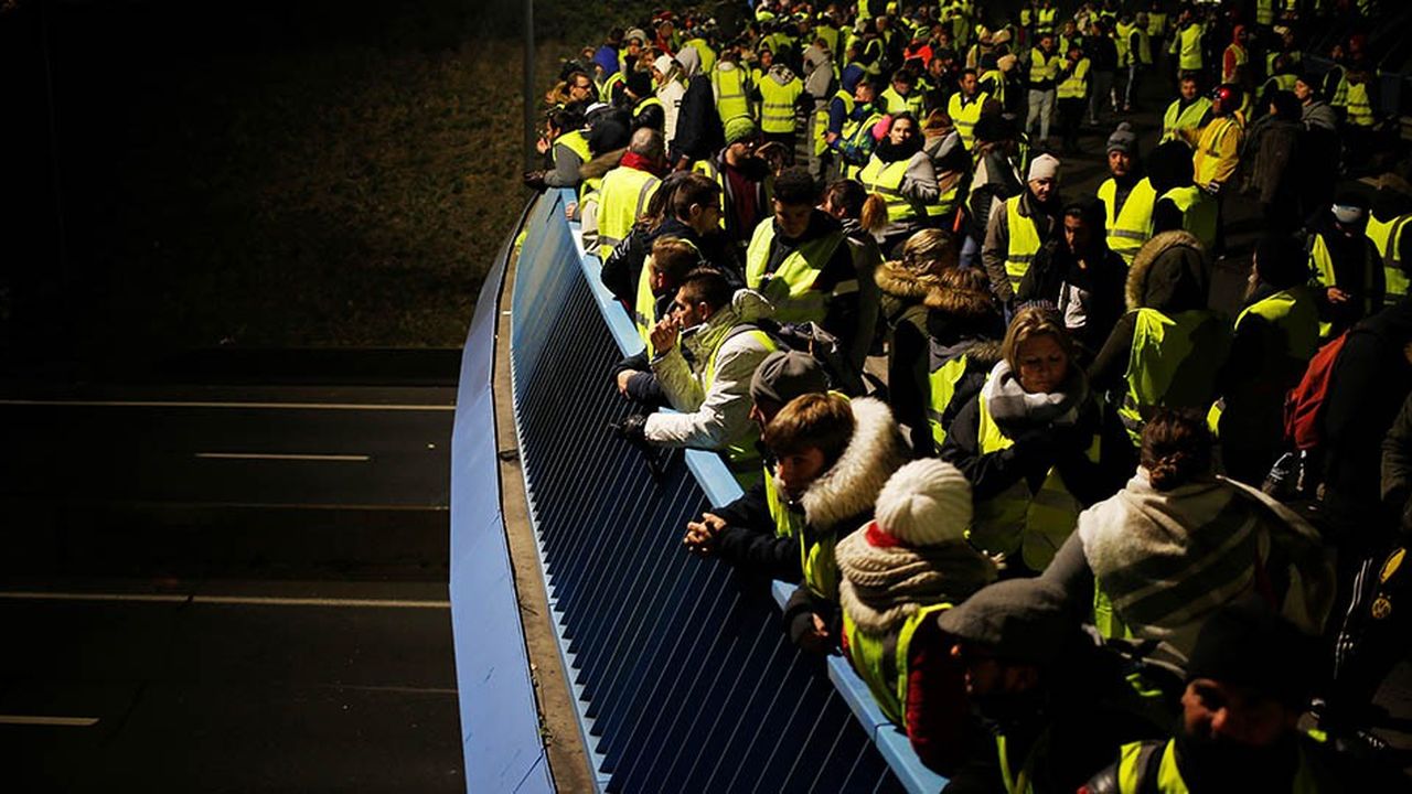 Des manifestants en « gilets jaunes », le 18 novembre, sur un pont autoroutier de Caen