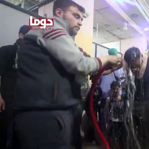 Une capture d'écran provenant d'une vidéo de la Douma City Coordination Committee montre un volontaire aspergeant d'eau une victime de l'attaque chimique du 7 avril.