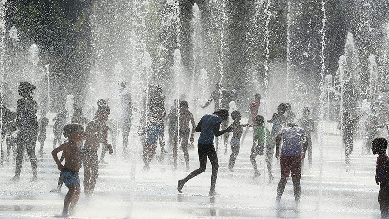 Enfants et adultes se rafraîchissant dans une fontaine à Nice, le 31 juillet 2018.