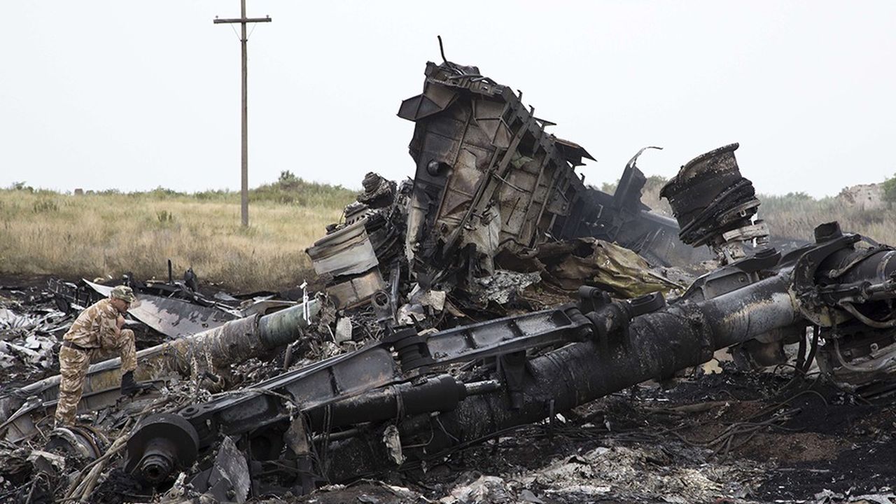 Un combattant pro-Moscou inspecte en juillet 2014 près du village de Hrabove, dans l'est de l'Ukraine les débris de l'avion de Malaysia Airlines où 298 personnes ont été tuées.