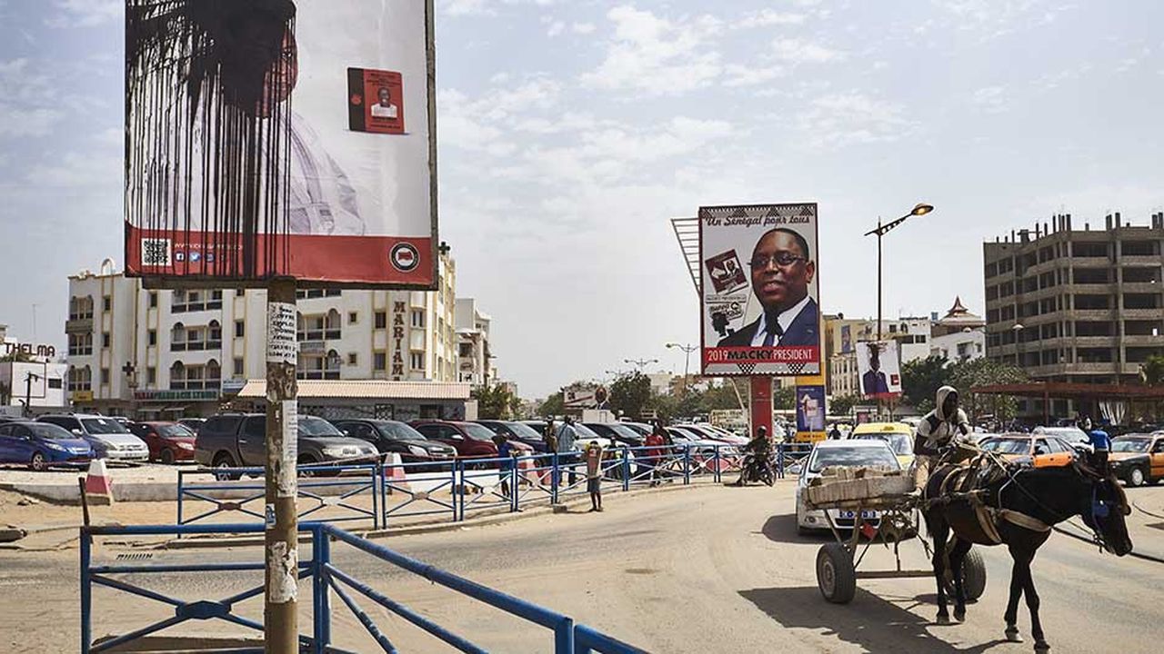 L'affiche vandalisée de l'ancien Premier ministre Idrissa Seck, à côté de celle du président Macky Sall illustre le climat tendu à la veille de la présidentielle de dimanche au Sénégal.
