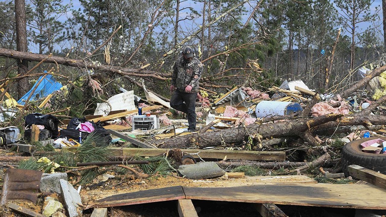 Vingt-quatre heures après une tornade qui s'est abattue le 3 mars sur l'Alabama faisant 23 morts, des résidents de Beauregard dans le comté de Lee tentent de retrouver des affaires dans leurs habitations détruites.