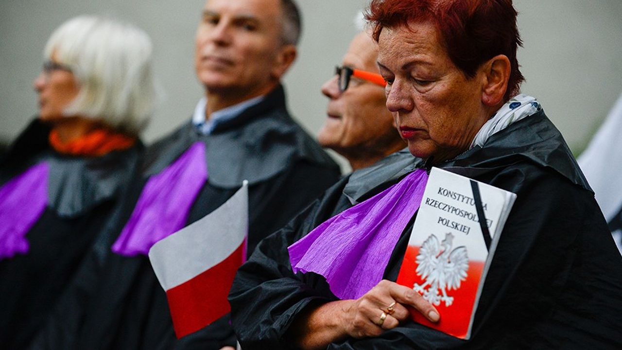 Une femme habillée en juge tient à la main la Constitution polonaise lors d'une manifestation contre la réforme de la Cour Suprême qui forçait certains juges à une retraite anticipée.