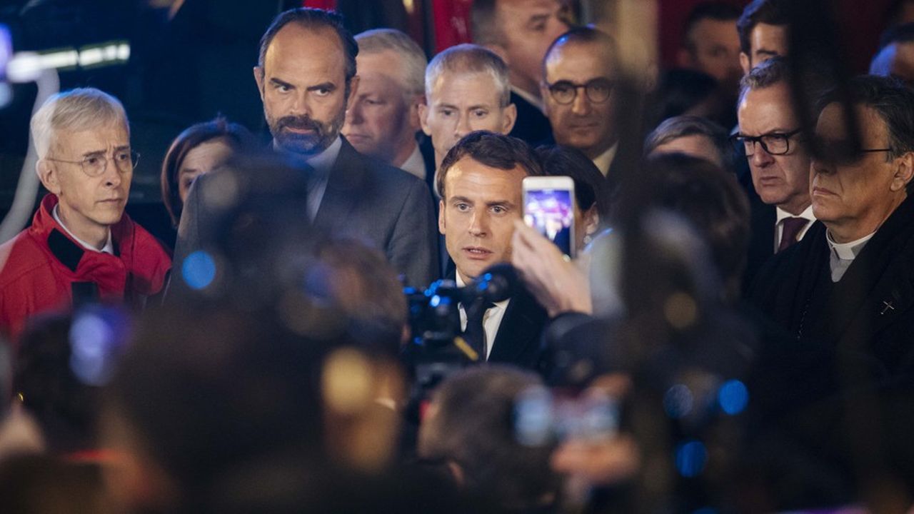 Emmanuel Macron est interrogé par des journalistes, à deux pas de la cathédrale Notre-Dame de Paris.