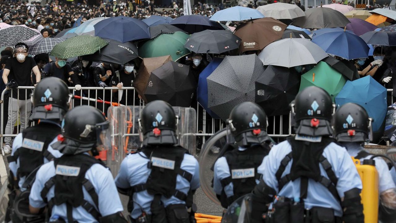 Les manifestants qui s'ooposent au projet de loi du gouvernement pro Pékin visant à faciliter les extraditions vers la Chine continentale se protègent de la police avec des parapluies.