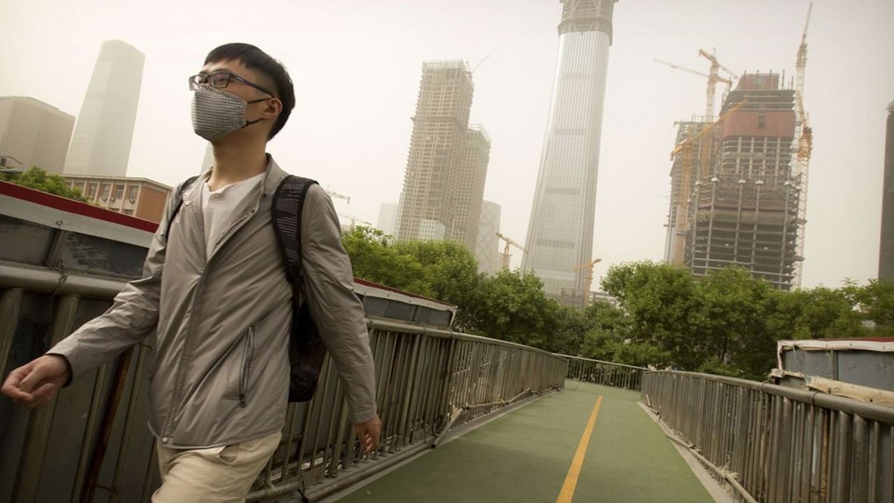 Un homme, à Pékin, en Chine, porte un masque sur le visage pour se protéger de la pollution.
