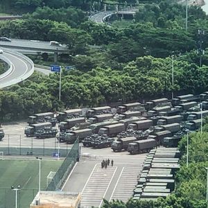 Des dizaines de camions de la police militaire chinoise se sont amassés autour du stade de Shenzhen, à quelques kilomètres de la frontière avec Hong Kong.