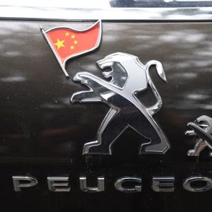 Un drapeau chinois sur le logo d'un véhicule Peugeot à Pékin, en 2018