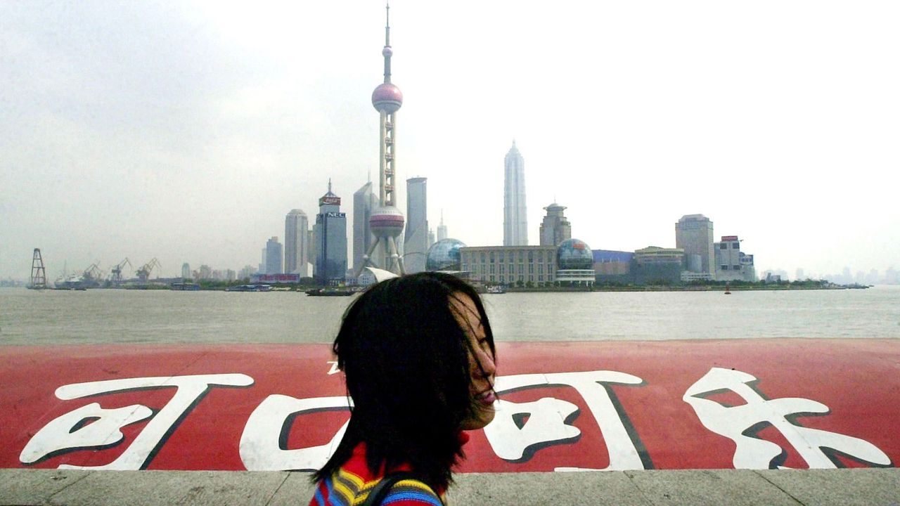 Une touriste passe devant une publicité pour Coca-Cola à Shanghai.