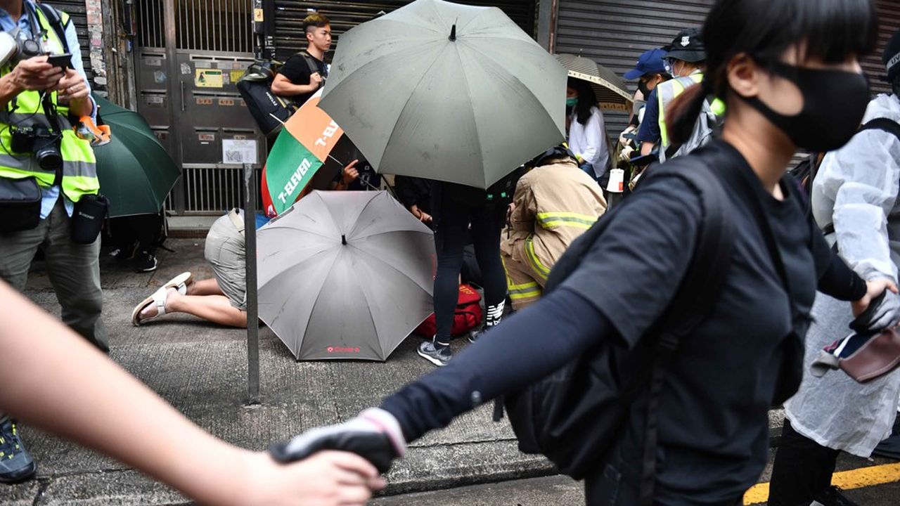 Des manifestants forment une chaîne humaine  pour protéger un des leurs à l'issue de nouveaux heurts à Hong Kong. 
