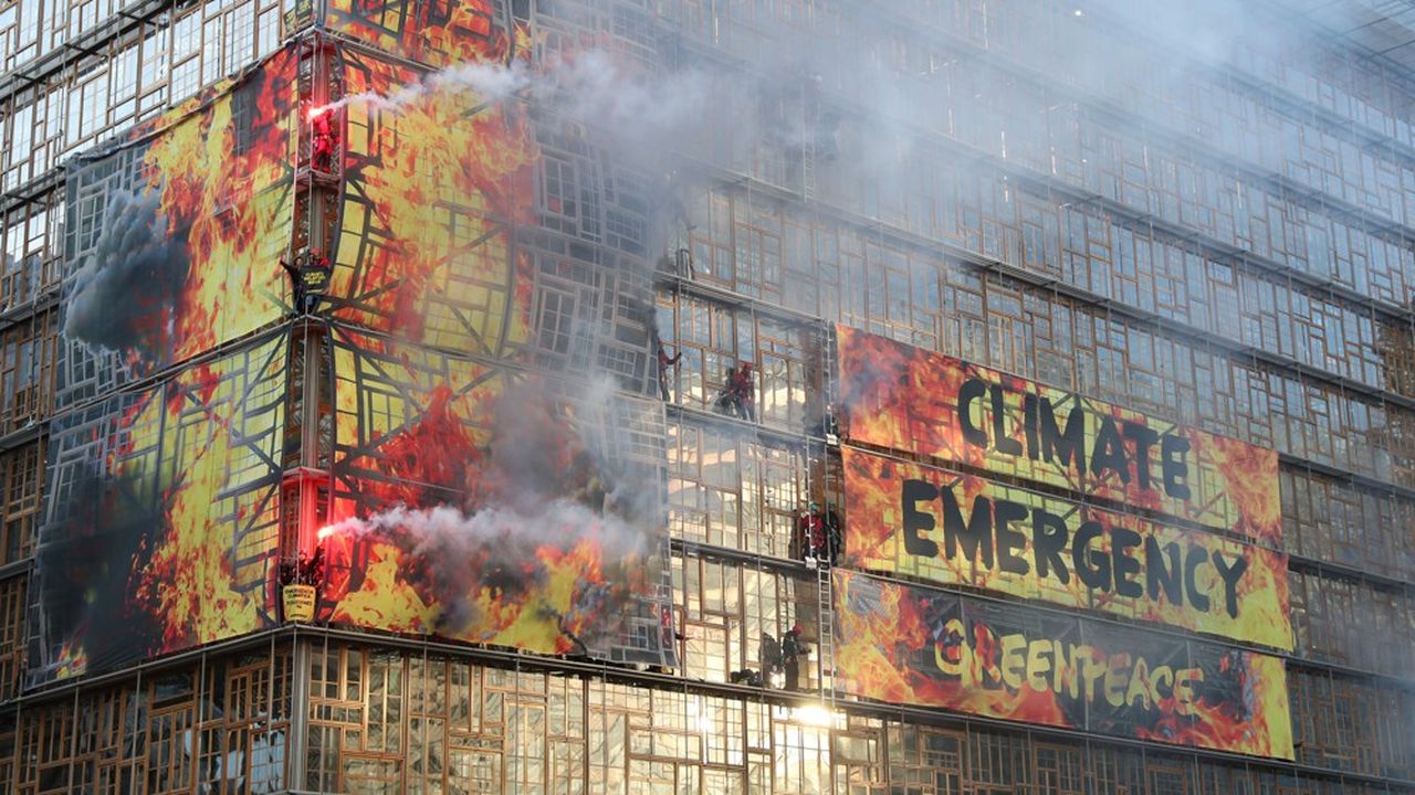 Des activistes de Greenpeace lancent des fumigènes sur les banderoles installées sur la façade du siège de la Commission européenne, à Bruxelles, lors du conseil des chefs d'Etat et de gouvernement, jeudi 12 décembre.