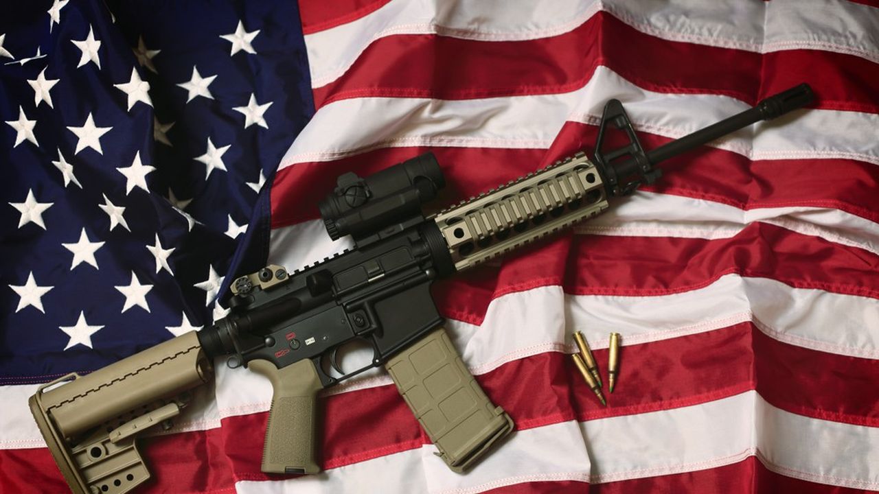 Un fusil d'assaut AR-15, déposé sur un drapeau américain comme symbole du droit des Américains à porter des armes, garanti par le deuxième amendement de la Constitution.