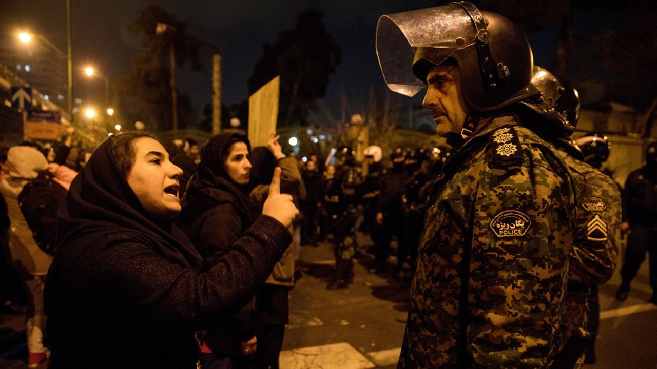 Une femme admoneste un policier devant l'université Amirkabir à Téhéran.