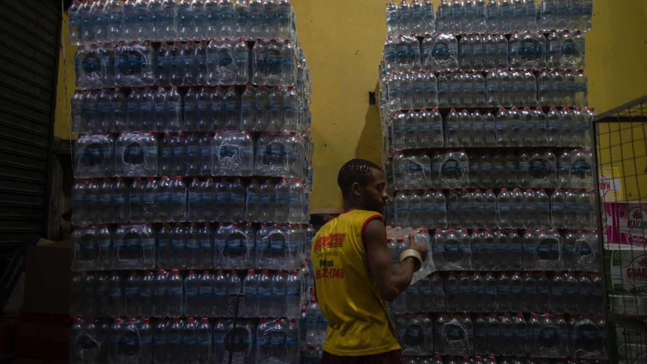 Un manutentionnaire d'un supermarché à Rio déstocke les packs d'eau sur lesquels la population de la ville s'est ruée ces derniers jours.