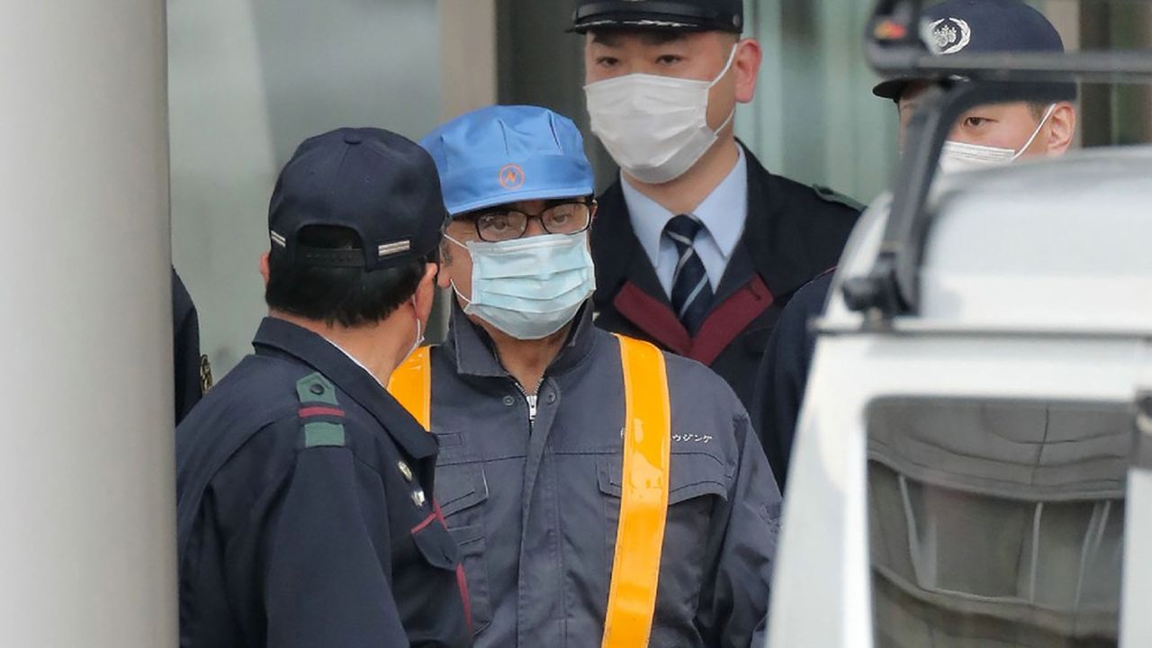 Carlos Ghosn (avec une casquette bleue) est escorté à la sortie de la prison de Tokyo, le 6 mars 2019.