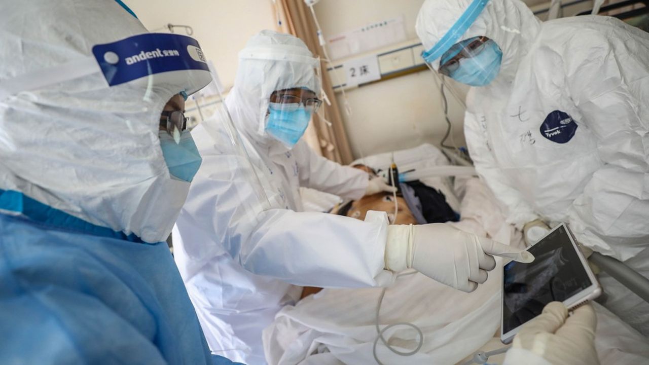 Des médecins auscultent un patient affecté par le coronavirus à l'hôpital de Wuhan.