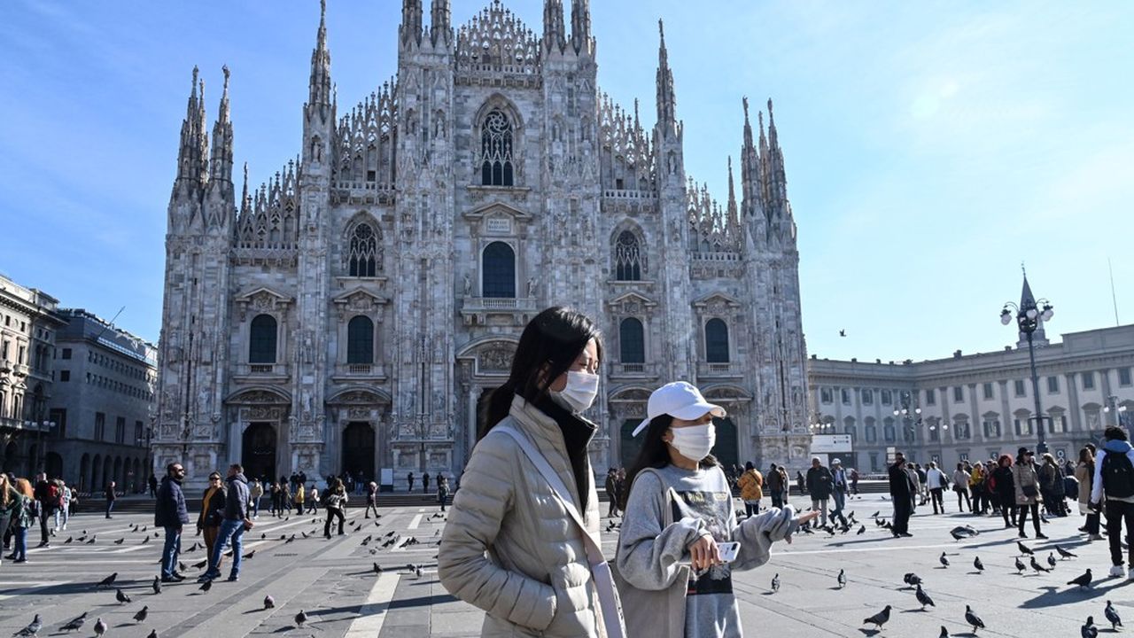 Deux femmes masquées pour se protéger du coronavirus se promènent sur la place du Duomo de Milan dont l'accès est fermé au grand public. L'Italie a dû mettre en quarantaine une douzaine de villes.