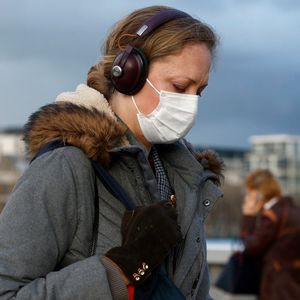 Une femme traverse le London Bridge protégée par un masque, le 3 mars 2020. REUTERS/Henry Nicholls