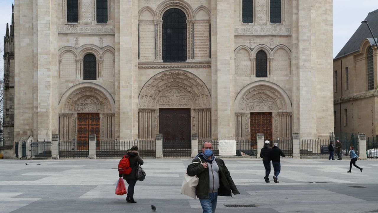 Des passants marchent en face de la basilique de Saint-Denis (93).