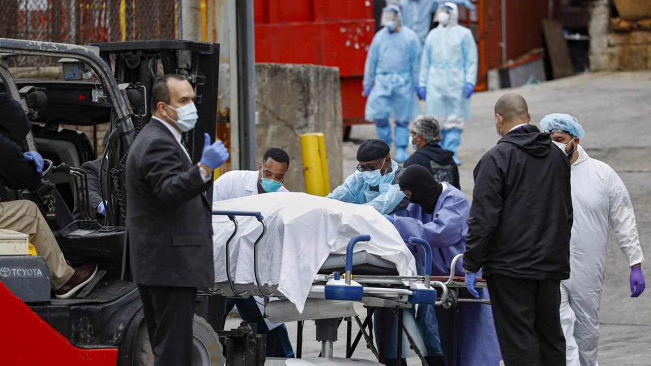 Des soignants du centre hospitalier de Brooklyn, à New York, conduisent un corps vers un camion réfrigéré.
