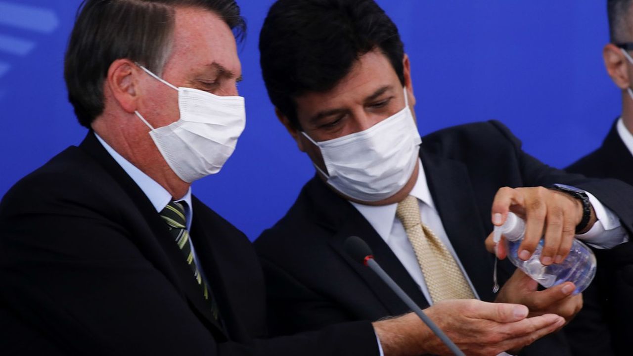 Le Président Jair Bolsonaro et le ministre sortant de la Santé Luiz Henrique Mandetta utilisent un gel hydroalcoolique avant une conférence de presse.