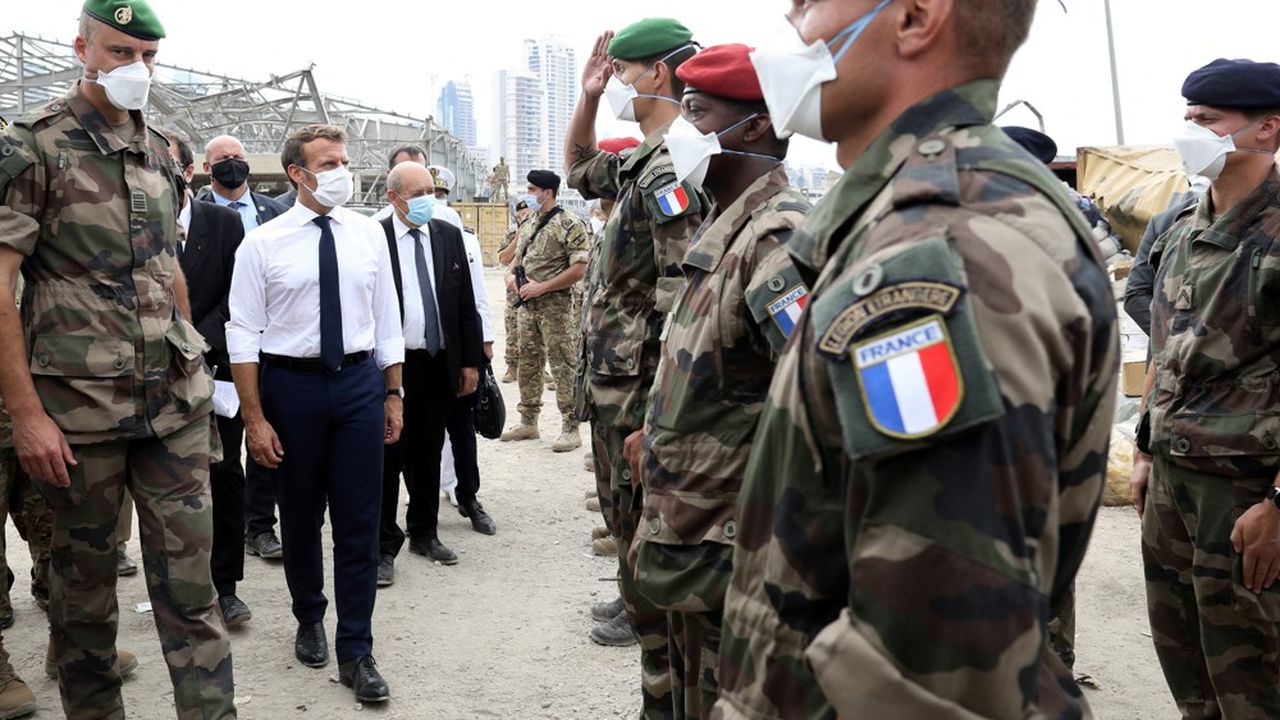 Le président Emmanuel Macron, accompagné de son ministre des Affaires étrangères, Jean-Yves Le Drian, passe en revue des militaires françaises déployés pour aider à la reconstruction du port de Beyrouth.