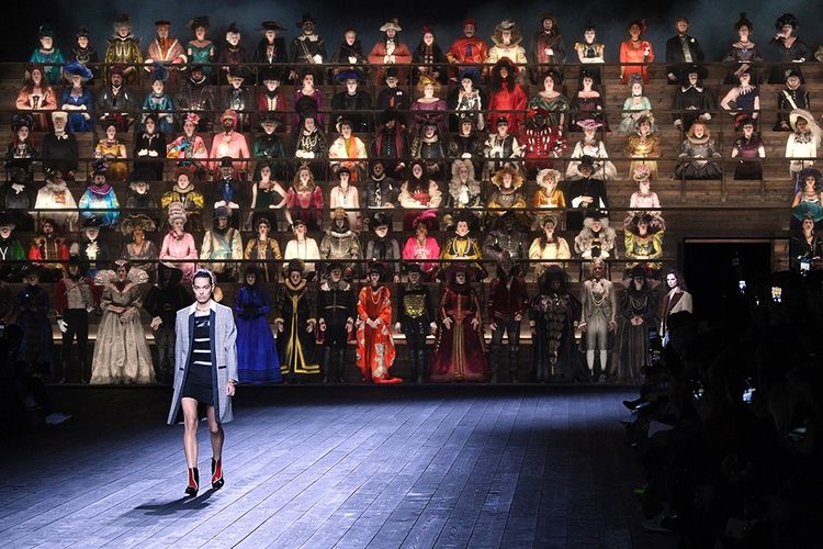 Défilé Louis Vuitton, prêt-à-porter automne-hiver 2020-21, le 3 mars dernier à Paris. Derrière le modèle, une estrade avec des figurants en habits, du xve siècle aux années 1950.