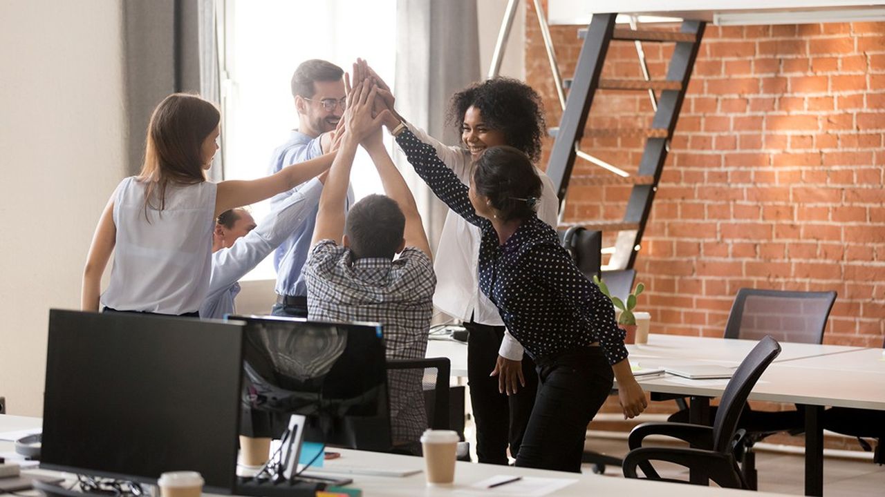 Happy motivated diverse office team giving high five together, excited multi-ethnic employees group celebrating reward, startup success, good teamwork result, engaging in teambuilding concept