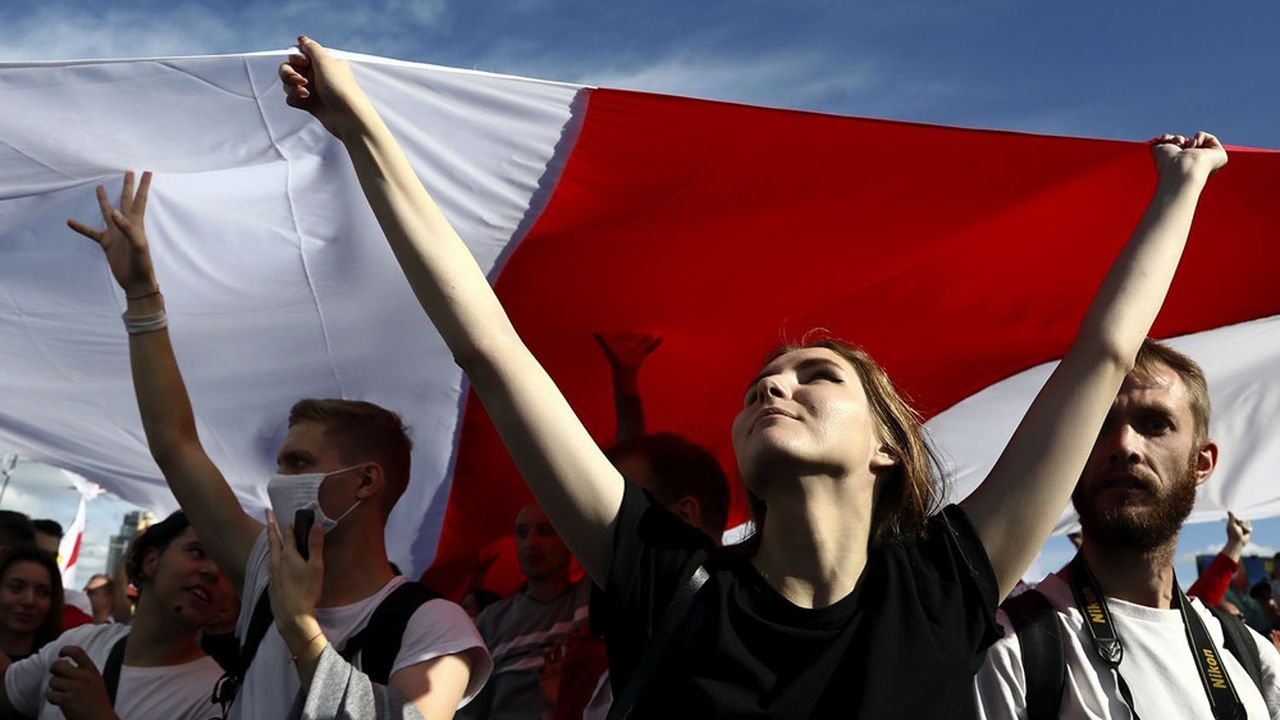 Des manifestants brandissent le drapeau biélorusse à Minsk.