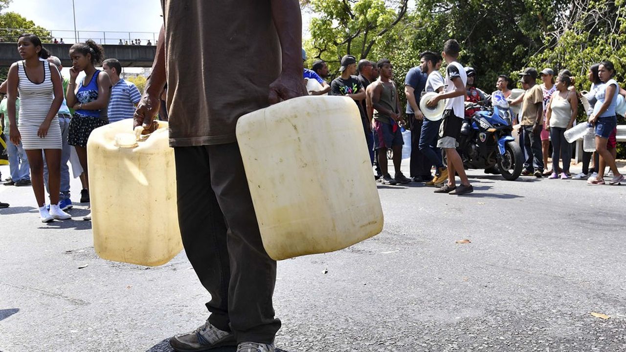 Dans la banlieue de Caracas, au Venezuela, plusieurs personnes font la queue pour de l'eau, en mars 2019. Les difficultés d'accès à l'eau potable font partie des dix périls à plus fort impact dans les prochaines années listés par le Forum économique mondial.