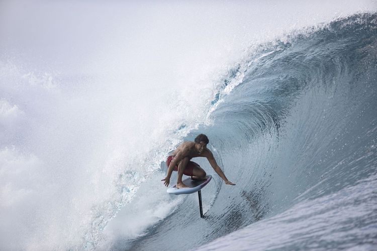 Le Tahitien Matahi Drollet sur son surf foil dans le « tube planétaire » de Teahupo'o, à Tahiti.