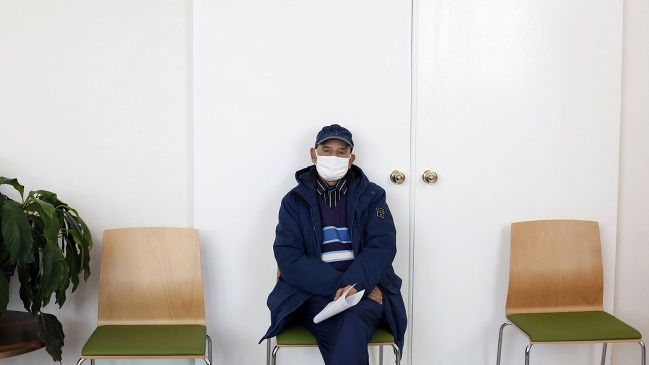 Un homme, dans un centre de vaccination de Saint-Denis, attend de recevoir une injection du vaccin Pfizer-BioNTech.