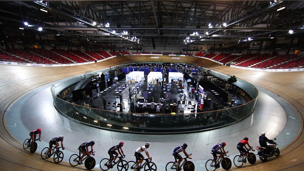 France's national cycling team trains as people get a dose of the 'Comirnaty' Pfizer-BioNTech COVID-19 vaccine at the indoor Velodrome National of Saint-Quentin-en-Yvelines in Montigny-le-Bretonneux, southwest of Paris, France, March 26, 2021. REUTERS/Gonzalo Fuentes