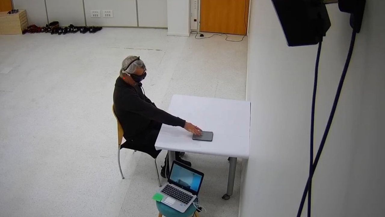 Extrait de la vidéo montrant le « patient 1.001 », muni de ses lunettes de stimulation lumineuse, désigner un objet de la main.