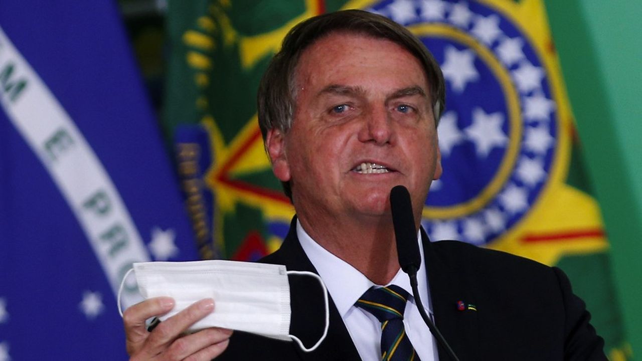 Le président brésilien tient à la main son masque lors d'une cérémonie au palais Planalto à Brasilia, le 10 juin 2021.