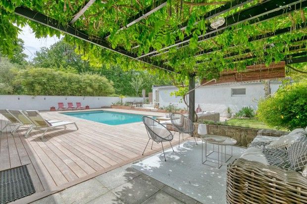 La maison, dressée sur un terrain de 2,7 hectares, bénéficie d'une terrasse aménagée et d'une piscine en pleine verdure. (Barnes)