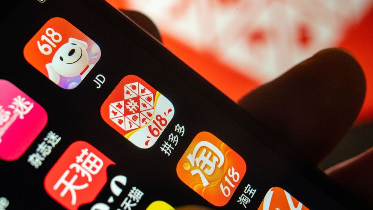 Le logo de l'application de Pinduoduo sur un smartphone, entre celles de JD.com (en haut à gauche) et celle d'Alibaba.