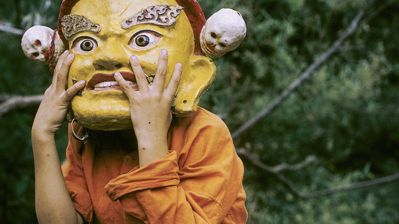 Un jeune novice joue avec un masque, avant une danse « Cham », rituel interprété par les moines bouddhistes tibétains.