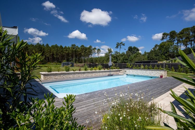 Le terrain de 2.500 m² se compose d'une piscine et d'un grand jardin, en lisière de forêt.