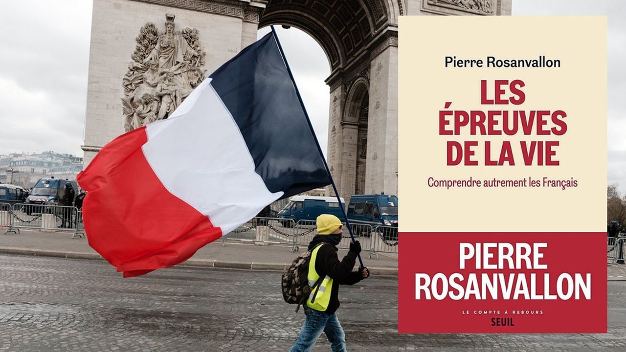 Paris, le samedi 16 mars 2019.Un « gilet jaune » brandit un drapeau de la France devant l'Arc de Triomphe.