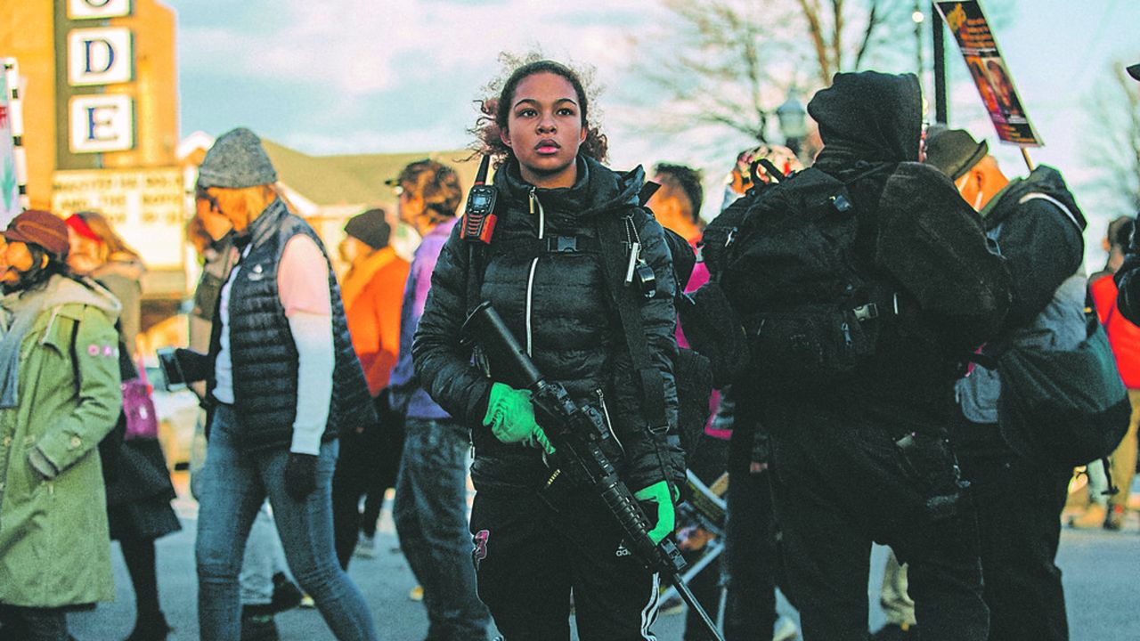 Une jeune fille de 16 ans monte la garde pendant que des militants protestent contre l'acquittement de Kyle Rittenhouse, le 21 novembre 2021, à Kenosha, Wisconsin.