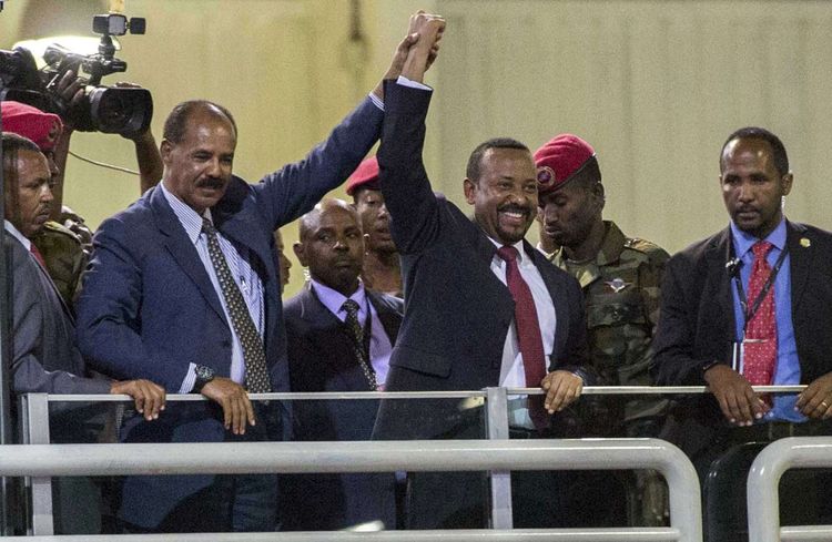 Le président de l'Erythrée, Isaias Afwerki, à gauche, et le Premier ministre de l'Ethiopie, Abiy Ahmed, au centre, saluent la foule à Addis Abeba, lors de la cérémonie marquant la fin de la guerre.