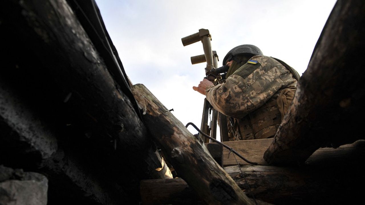 Un soldat ukrainien observe les forces ennemies près de la ligne de contact dans l'est du pays près du village abandonné de Talakivka.
