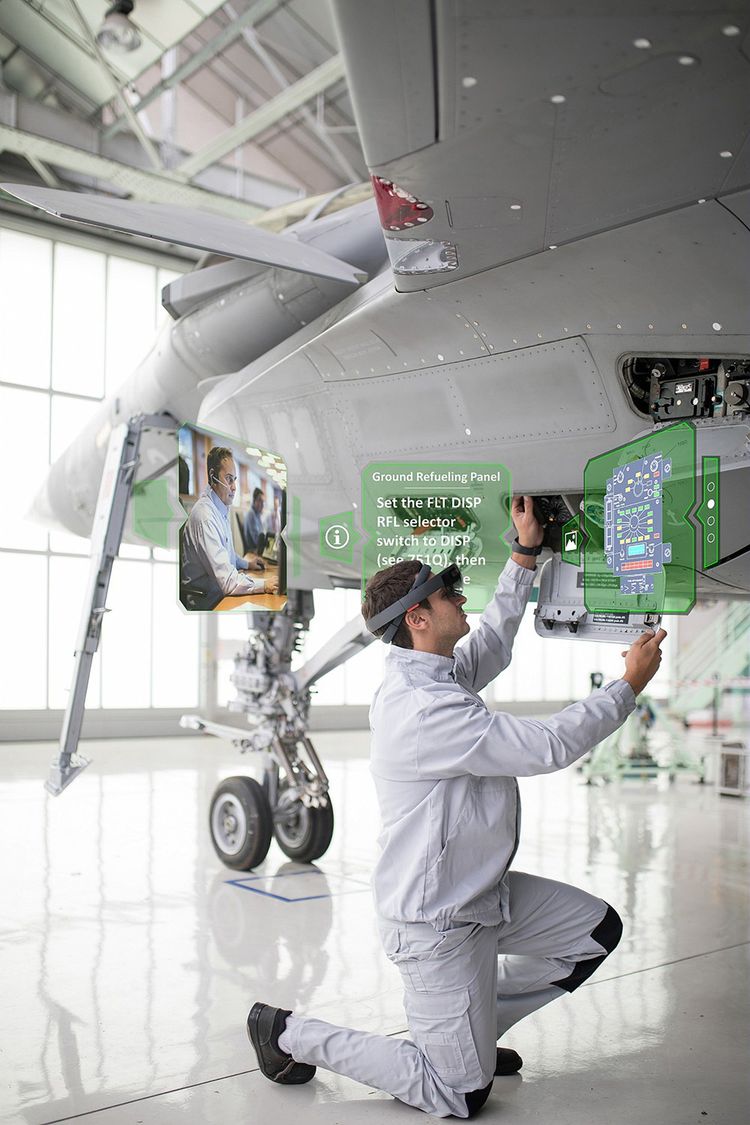 Un m écanicien équipé de lunettes de réalité virtuelle HoloLens travaille sur un avion Rafale.