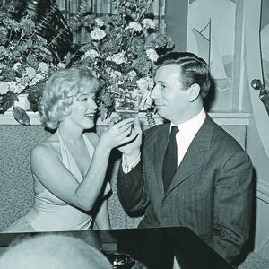 L'actrice Marilyn Monroe, amatrice de champagne, aux côtés de l'acteur Yves Montand.