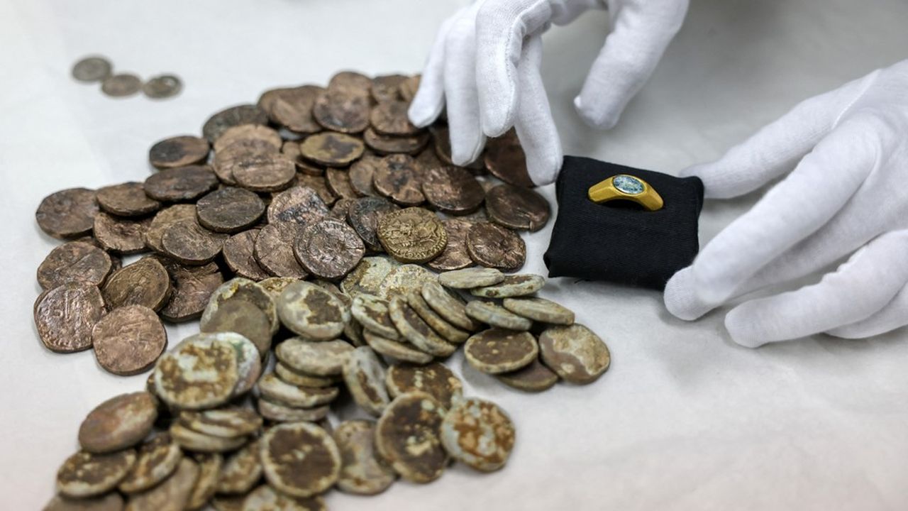 Des pièces de monnaie et une bague en or portant le symbole du Bon Pasteur, l'une des premières expressions à faire référence à Jésus, sont exposées au laboratoire de l'Autorité israélienne des antiquités à Jérusalem, le 22 décembre 2021.