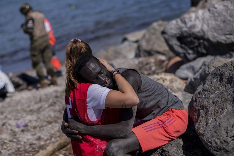 Un migrant est réconforté par un membre de la Croix-Rouge espagnole près de la frontière entre le Maroc et l'Espagne, dans l'enclave espagnole de Ceuta, le 18 mai.