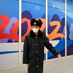 Un agent de sécurité guide les passagers au sein de la « bulle sanitaire » dans une gare voisine de Pékin à la veille des Jeux d'hiver.