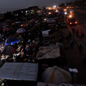 Des vendeurs en bordure de route exposent des marchandises sur un marché sans électricité à Ibafo, dans l'Etat d'Ogun, dans le sud-ouest du Nigeria, le 22 mars 2022.
