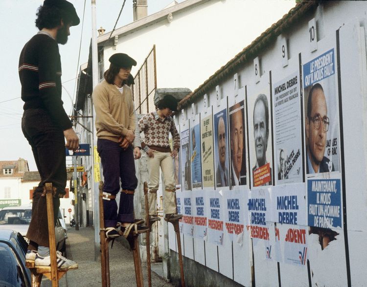 Des promeneurs sur échasses regardent les panneaux électoraux, le 26 avril 1981 dans les Landes, le jour du premier tour de l'élection présidentielle.